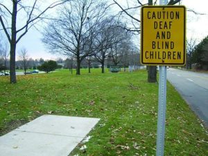 A sidewalk that ends in grass.