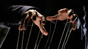 Puppet master's hands and strings.