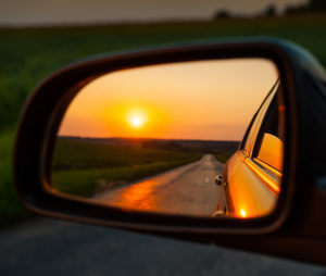 View of a sunset through a rear view mirror.