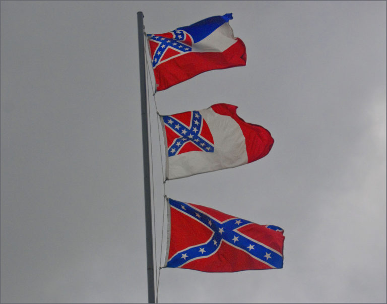 Flags over Mississippi, including the state flag of Mississippi and the Confederate Battle flag.