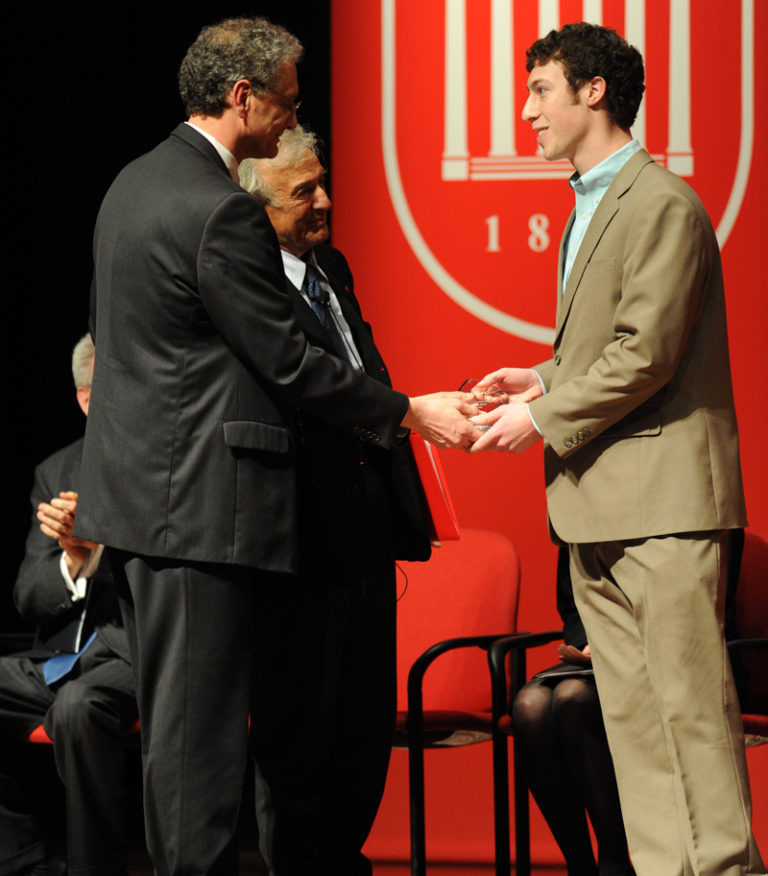 Photo of Taylor McGraw being congratulated by Dean Doug Sullivan-Gonzalez and Nobel Laureate Elie Wiesel, 2010.
