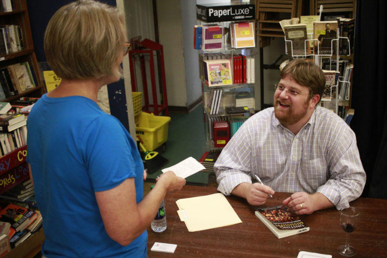 Photo of Weber signing a book for Mrs. Gray in Oxford, MS.