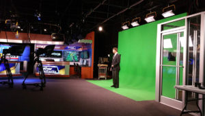 Photo of the weatherman in front of a green screen in Tupelo, MS's WLOV TV studio.
