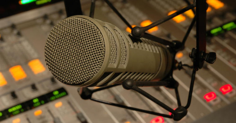 Photo of a microphone in front of a soundboard.