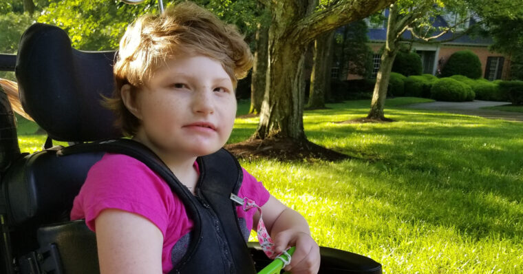 This photo features my daughter, Helen, in 2019, sitting in her wheelchair and awaiting the school bus on a sunny morning.