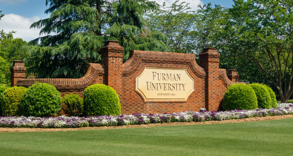 This image shows a large brick sign featuring the name Furman University.